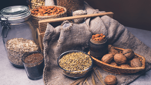 Different types of nuts and seeds in jars, and bowls