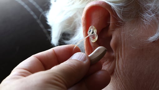 A person getting their hearing aid placed in their ear