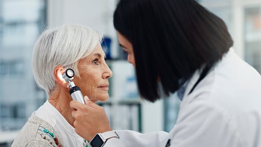 A older adult woman at the doctor getting her ears and hearing examined