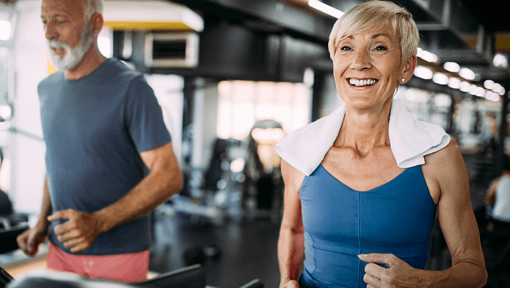 An older adult man and woman doing high intensity interval training at the gym
