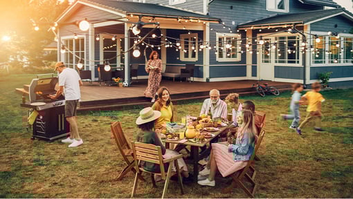 A big group of people enjoying a dinner in a backyard