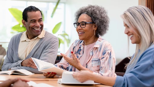 hree adults socially engaging at a their bookclub meeting