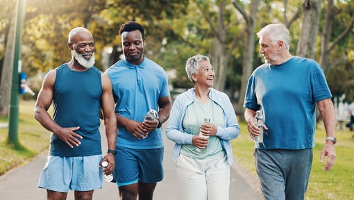 Three senior aged people and one person who is middle aged walking outside showing that a daily routine nurtures your well-being.