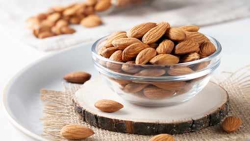 Bowl of almonds that are to be added as the finishing touch to the orange, avocado, and spinach salad.