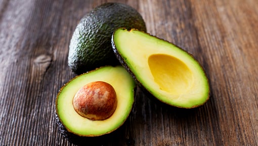 Image of an avocado sliced in half, avocado is a great source of healthy fat and other nutrients.