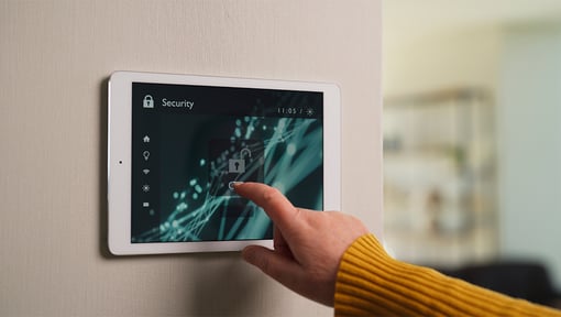 A hand is unlocking a smart home security system 