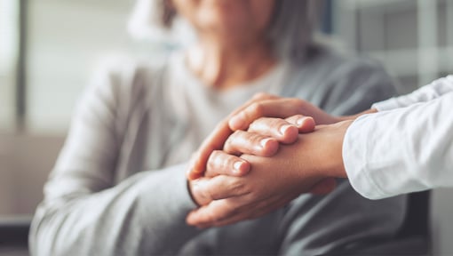 Close-up of a supportive hand-holding gesture during a empathetic conversation.