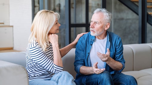 Two older adults having a supportive conversation at home, they are practicing active listening and empathy.